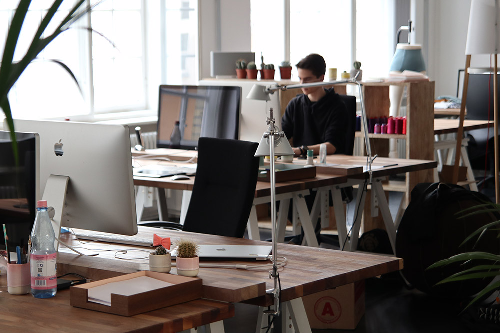 jeune homme travaillant sur ordinateur dans un open space